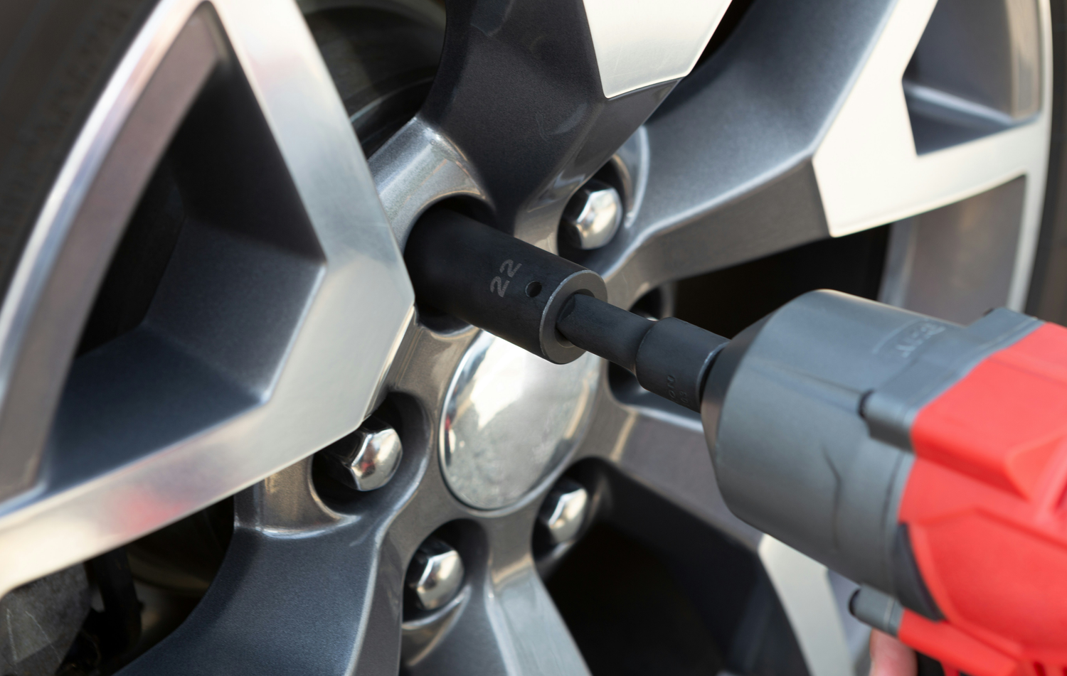 Wheel bolts being removed from vehicle.